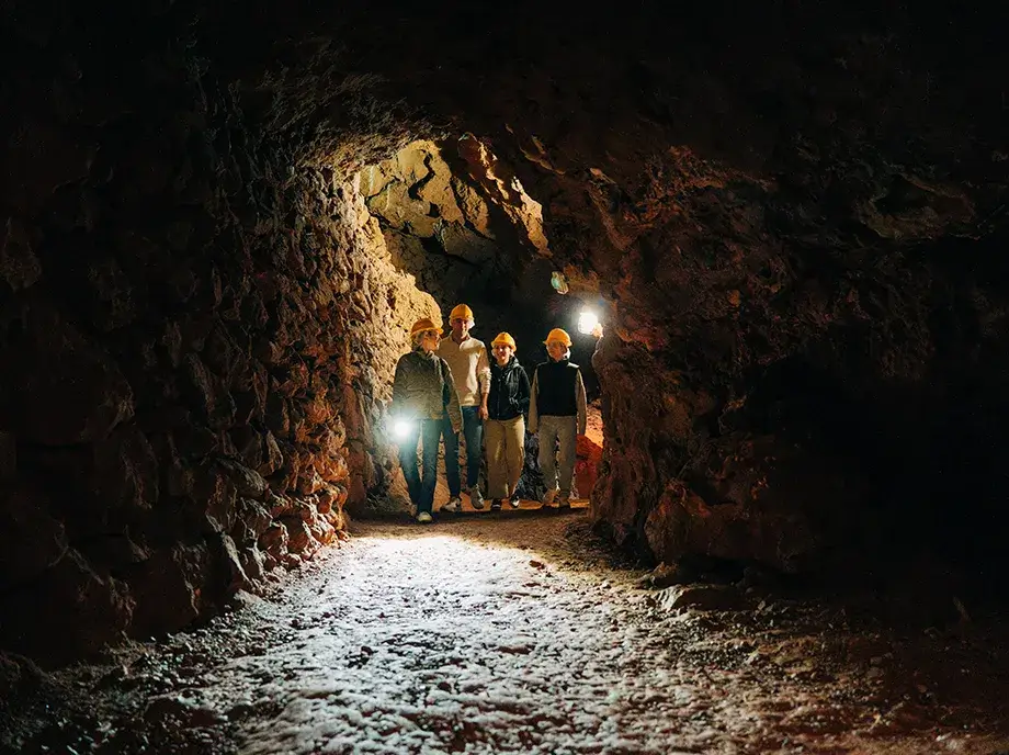 Grupo de visitantes con casco en el interior de una antigua mina del Parc Miner del Maestrat