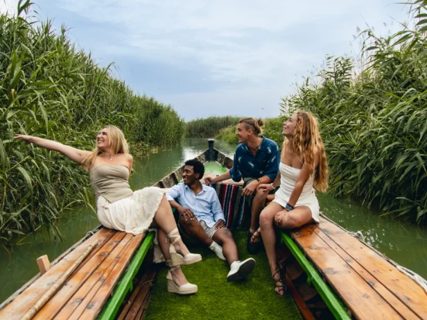 Grupa podróżująca po jeziorze Albufera łodzią elektryczną.