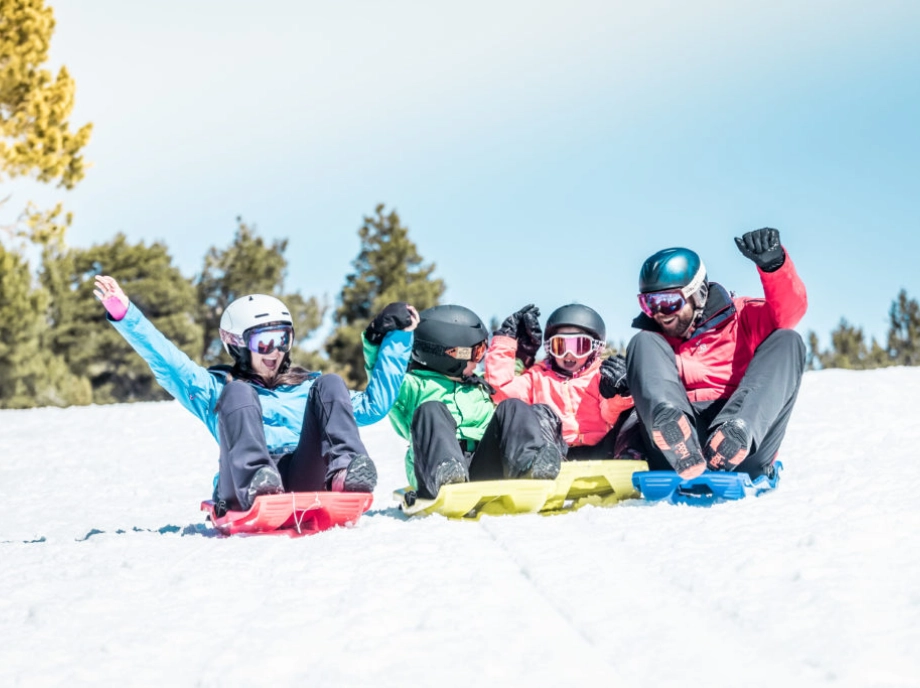 Famille faisant de la luge dans la neige